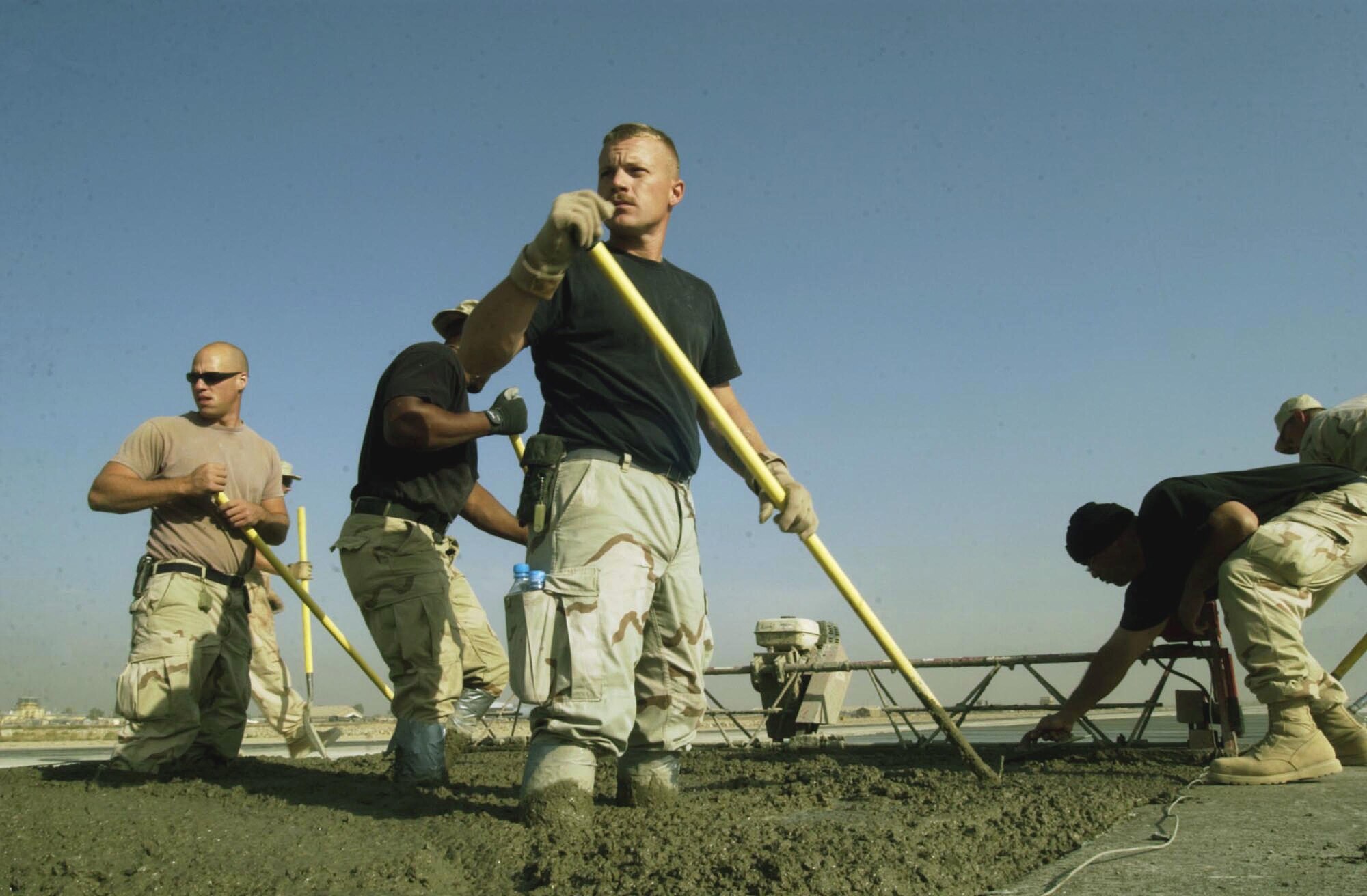 BAGRAM AIR BASE, Afghanistan -- Staff Sgt. Joseph Adair, of the 455th Expeditionary Support Squadron, stands in 12 inches of concrete as he, and the rest of his team, work on the last strip of the runway here before completion.  (U.S. Air Force photo by Staff Sgt. Russell Wicke)