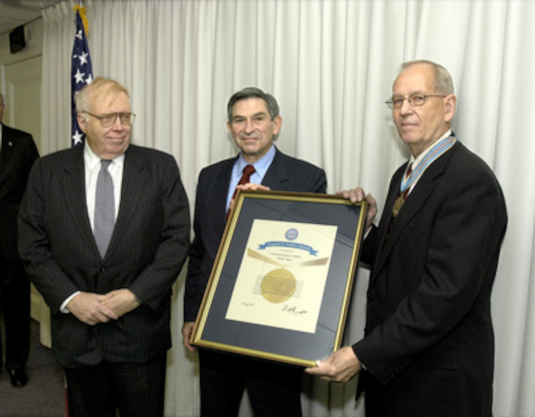 The Eugene G. Fubini Award for 2003 is presented to Larry D. Welch (right) by Deputy Secretary of Defense Paul Wolfowitz (center) while Chairman of the Defense Science Board William Schneider Jr. (left) looks on in the Pentagon on Oct. 23, 2003. The Fubini Award recognizes highly significant contributions to the Department of Defense in an advisory capacity over a sustained period of time. Welch, a retired Air Force general and former Air Force chief of staff, has provided expert advise on a diverse range of issues including ballistic missile defense, weapons of mass destruction threats, strategic road maps, operational plans and various transformational technologies. 