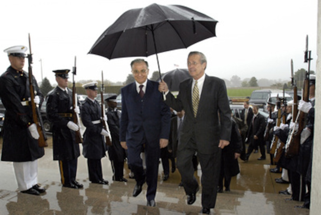 Secretary of Defense Donald H. Rumsfeld (right) escorts President Ion Iliescu (left) of Romania through a joint service honor cordon and into the Pentagon on Oct. 27, 2003. Rumsfeld hosted a working luncheon for the president and his delegation in the Pentagon's Eisenhower Dining Room. 