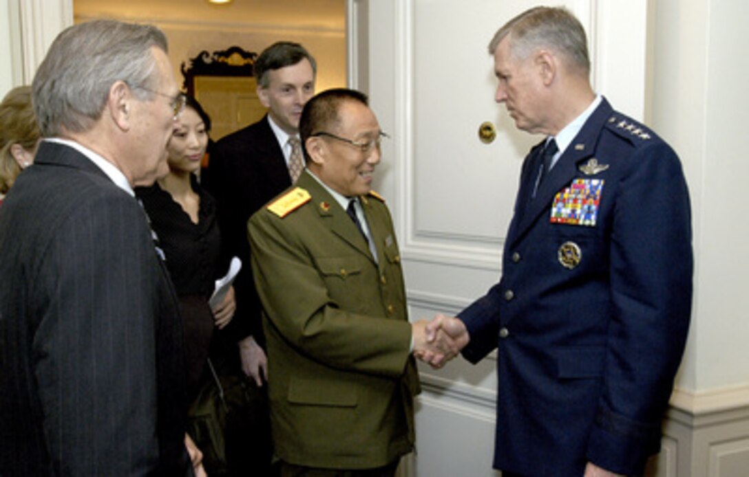 Gen. Richard B. Myers (right), chairman of the Joint Chiefs of Staff, welcomes Gen. Cao Gangchuan, the minister of defense of the Peoples Republic of China, to the Pentagon on Oct. 28, 2003. Cao is the guest of honor at a working lunch hosted by Secretary of Defense Donald H. Rumsfeld (left). The defense leaders discussed a broad range of bilateral as well as international security issues. 