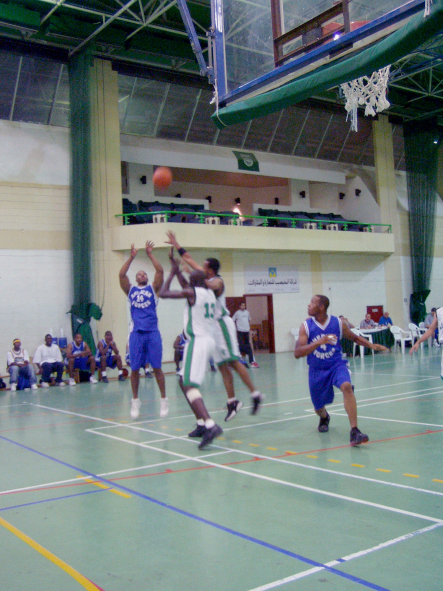 DOHA, Qatar -- Ishman Woodard (14) shoots while American teammate Will Spencer (4) gets in position for a rebound.  The team lost Oct. 22 to Al Ahli, 66-63, in a scrimmage game here.  Its members will become the first Americans to play in the nation's capitol city league Nov. 9.  Woodard is a senior airman assigned with the Combined Air Operations Center at Al Udeid Air Base.  He is deployed from Barksdale Air Force Base, La.  Spencer is an airman first class assigned to the 1st Expeditionary Red Horse Group and is deployed from Nellis AFB, Nev.  (U.S. Air Force photo by Master Sgt. William J. Sharp)