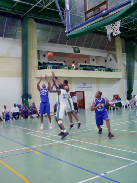 DOHA, Qatar -- Ishman Woodard (14) shoots while American teammate Will Spencer (4) gets in position for a rebound.  The team lost Oct. 22 to Al Ahli, 66-63, in a scrimmage game here.  Its members will become the first Americans to play in the nation's capitol city league Nov. 9.  Woodard is a senior airman assigned with the Combined Air Operations Center at Al Udeid Air Base.  He is deployed from Barksdale Air Force Base, La.  Spencer is an airman first class assigned to the 1st Expeditionary Red Horse Group and is deployed from Nellis AFB, Nev.  (U.S. Air Force photo by Master Sgt. William J. Sharp)