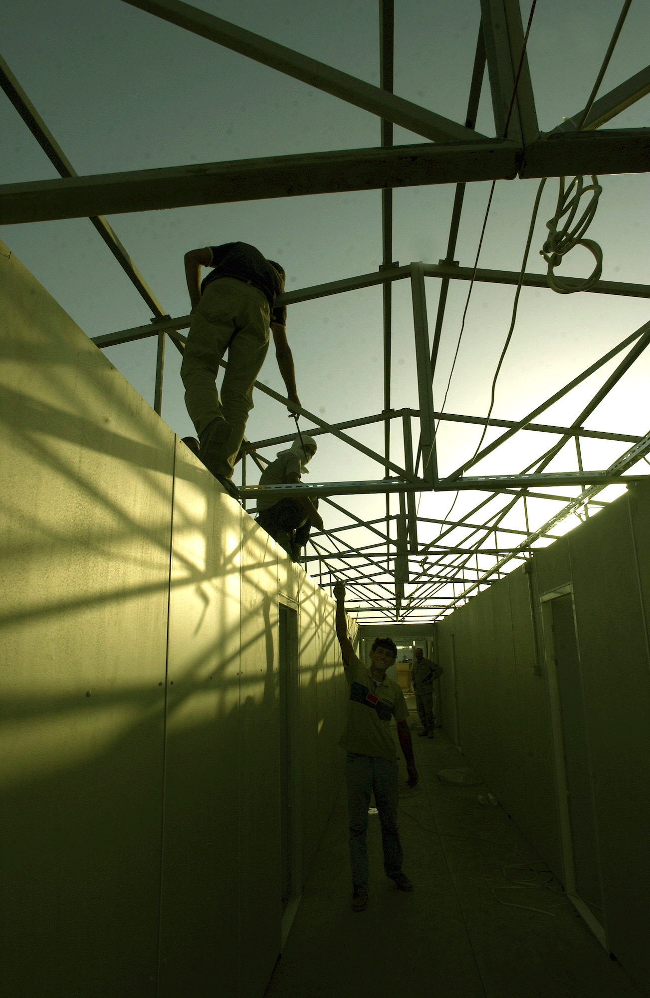 KIRKUK AIR BASE, Iraq -- Contractors work into the evening to complete a dormitory that will house up to 1,664 airmen in 13 buildings with six to eight people to a room.  The new dorms are scheduled to open Dec. 1.  The units were originally purchased by U.S. Air Forces in Europe and earmarked for construction at Incirlik Air Base, Turkey, for Operation Northern Watch.  (U.S. Air Force photo by Master Sgt. Keith Reed)