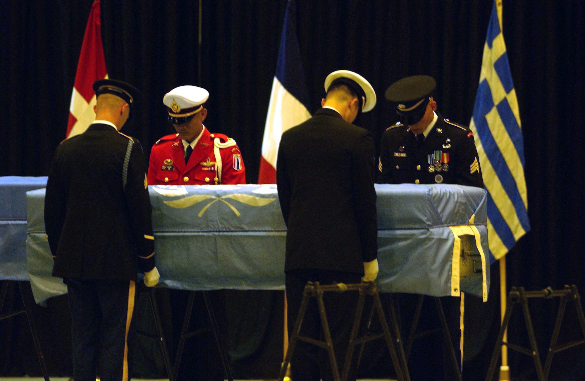 YOKOTA AIR BASE, Japan -- Members of the U.N. Honor Guard pay their final respect to remains believed to be those of U.S. soldiers during a repatriation ceremony here Oct. 28.  Eight caskets, each draped in a pale blue U.N. flag, were carried by military honor guards into a hangar after being flown in from North Korea.  (U.S. Air Force photo by Master Sgt. Val Gempis)