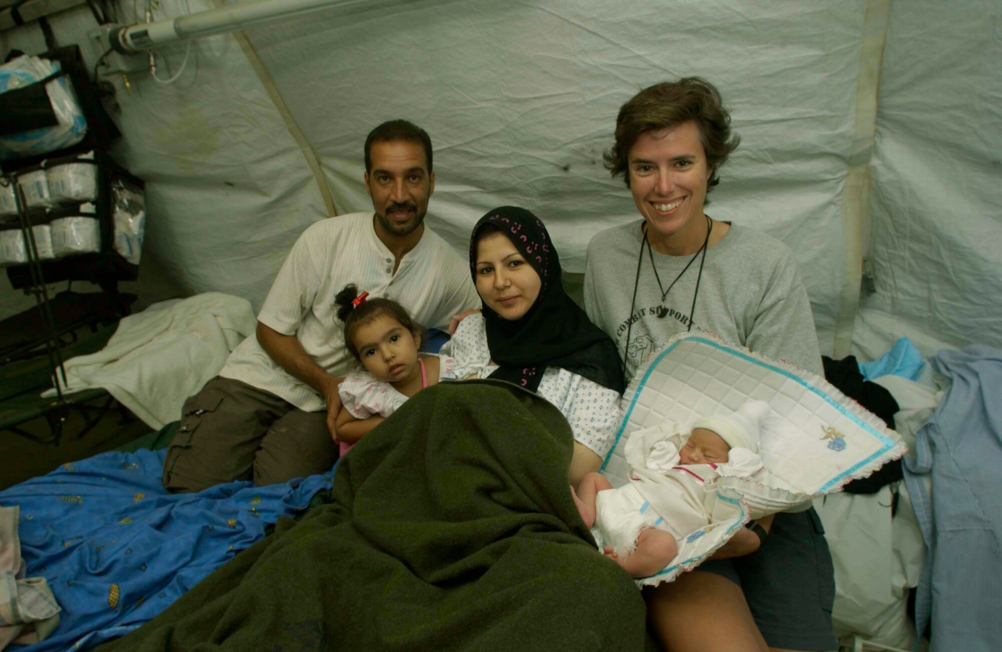 TALLIL AIR BASE, Iraq -- Army Maj. (Dr.) Elizabeth Shanley (right) spends time with the Alrikabi family (left to right) Moslem, Al'aa, Rafah and baby Malach.  Shanley, a physician with the 332nd Expeditionary Medical Group, delivered Malach, the first child born here.  (U.S. Air Force photo by Master Sgt. Lance Cheung)