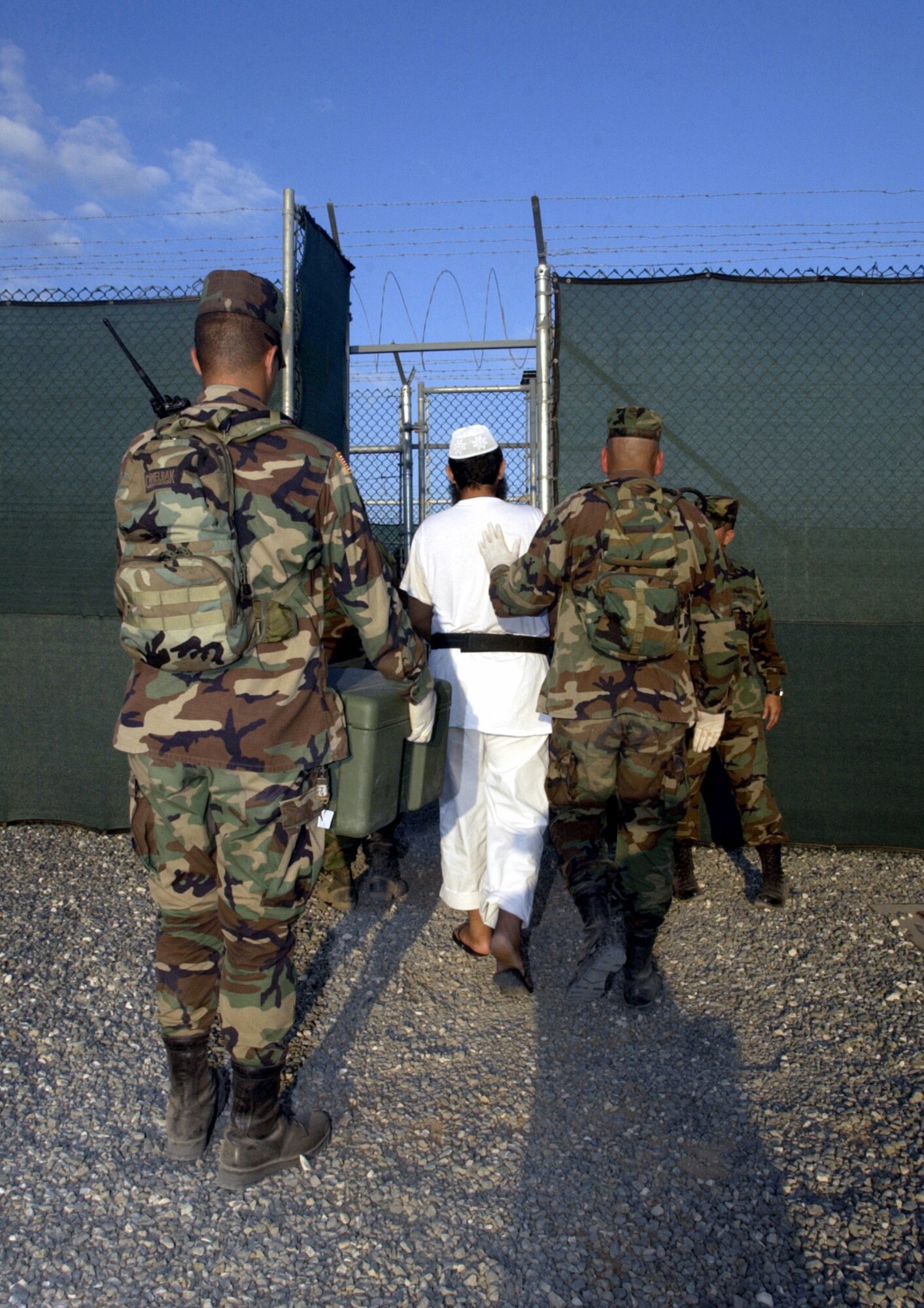 U.S. NAVAL BASE GUANTANAMO BAY, Cuba -- A detainee is escorted to a medium-security facility here that houses detainees in a communal living environment.  (Department of Defense photo by Navy Seaman David P. Coleman)