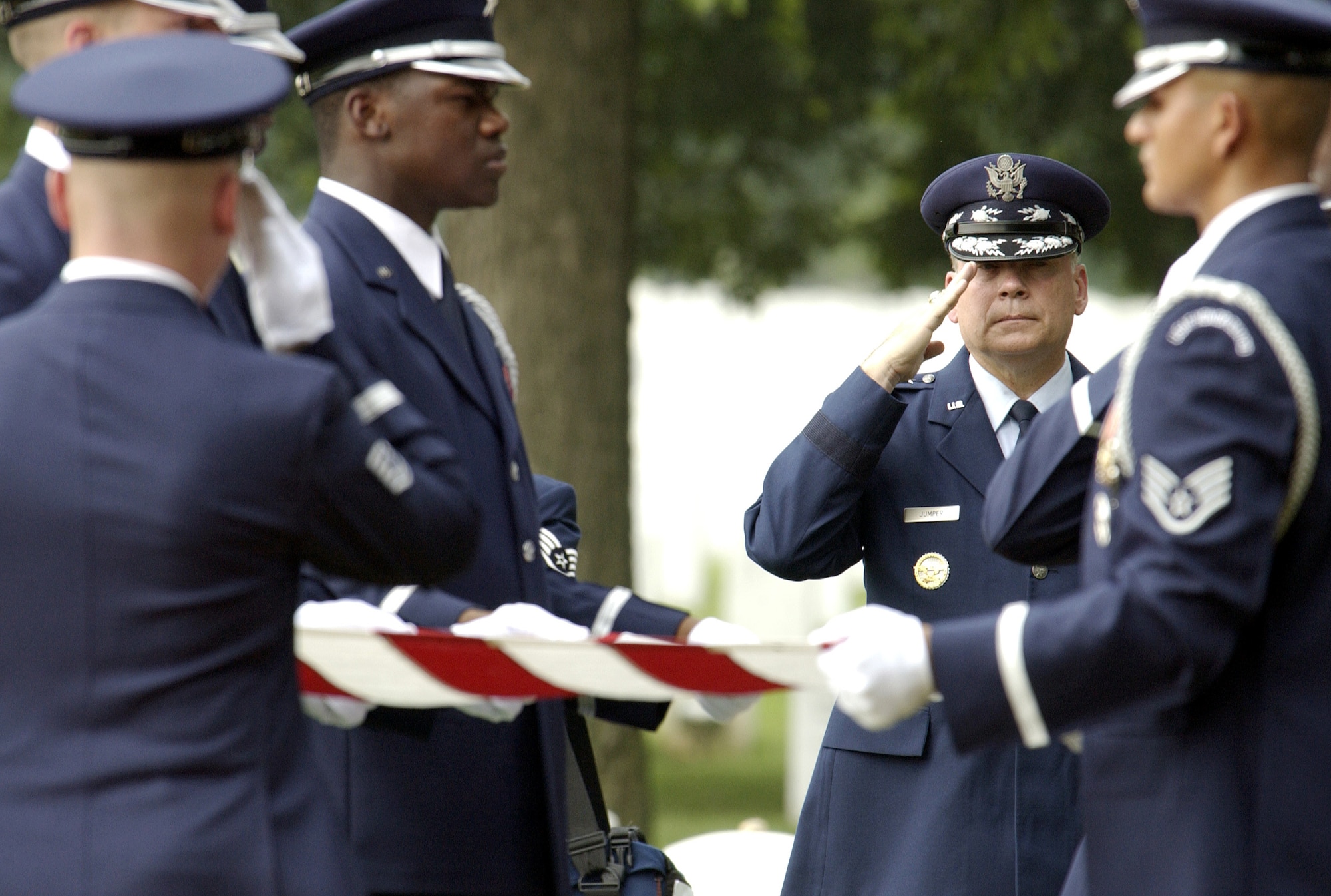 ARLINGTON, Va. -- Air Force Chief of Staff Gen. John P. Jumper salutes as Air Force Honor Guard members fold a flag during a funeral ceremony Aug. 29 for Lt. Col. William R. Watkins III and Capt. Eric B. Das at Arlington National Cemetery.  Watkins and Das were killed April 7 when their F-15E Strike Eagle went down on a combat mission over Iraq.  The fliers were assigned to the 333rd Fighter Squadron at Seymour Johnson Air Force Base, N.C.  (U.S. Air Force photo by Staff Sgt. Melissa Allan)