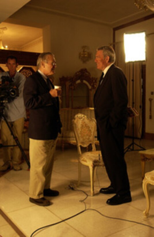 Secretary of Defense Donald H. Rumsfeld talks with Dan Rather of CBS News before an interview for the network's evening news on Sept. 5, 2003, in Baghdad, Iraq. 