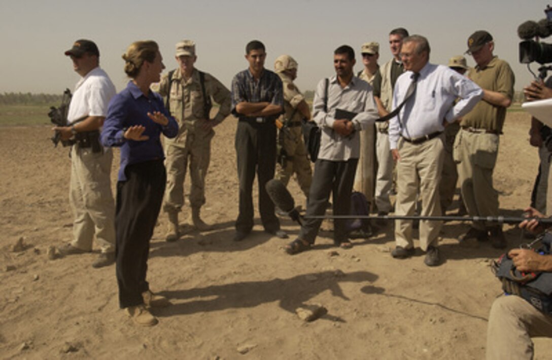 Coalition Provisional Authority Human Rights Officer Sandy Hodgkinson briefs Secretary of Defense Donald H. Rumsfeld on the Mahawil Mass Grave site on Sept. 6, 2003, in Iraq. 