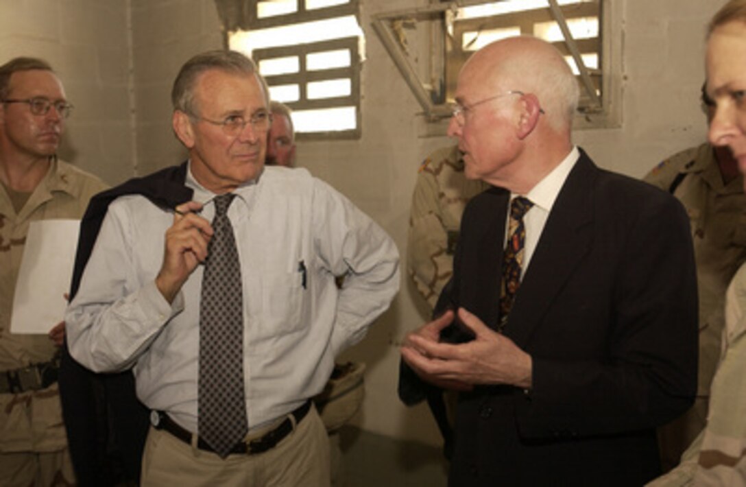 Secretary of Defense Donald H. Rumsfeld listens to the Coalition Provisional Authority Senior Advisor to the Ministry of Justice Judge D. Campbell speak about the Abu Gharib Prison on Sept. 6, 2003, in Iraq. 
