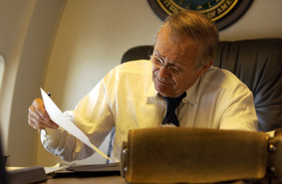 Secretary of Defense Donald Rumsfeld catches up on paperwork while en route to Iraq and Afghanistan on Sept. 3, 2003. 