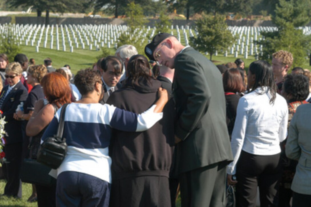 At the Arlington National Cemetery Patriot's Day observance, Sept. 11, 2003, an Army chaplain comforts the spouse of one of the victims of the Sept. 11, 2001, terrorist attack on the Pentagon. During the ceremony, Secretary of Defense Donald H. Rumsfeld and Chairman of the Joint Chiefs of Staff Gen. Richard B. Myers placed a floral wreath at the memorial to the 184 victims of the attack. 