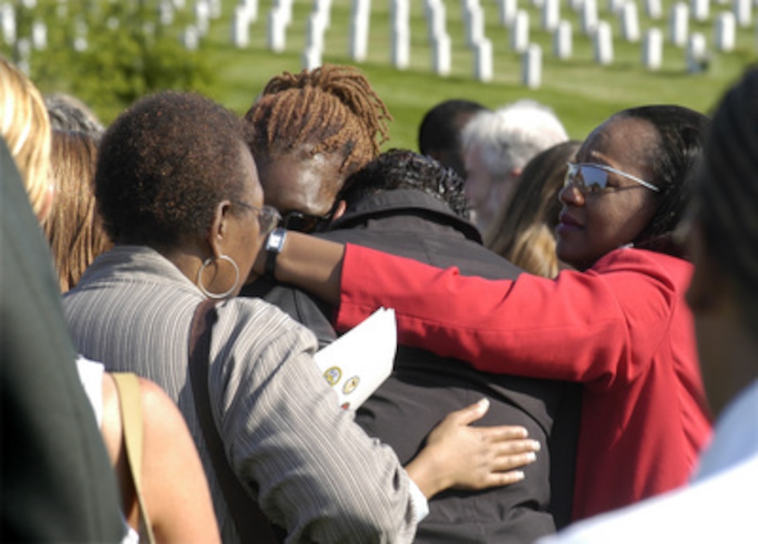 Family members of one of the victims of the Sept. 11, 2001, terrorist attack on the Pentagon are overcome with grief during Patriot's Day observances at Arlington National Cemetery marking the second anniversary of the attack. Secretary of Defense Donald H. Rumsfeld and Chairman of the Joint Chiefs of Staff Gen. Richard B. Myers spoke at the event and placed a floral wreath at the monument to the 184 victims. 