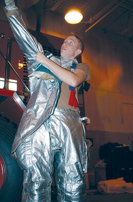 EIELSON AIR FORCE BASE, Alaska -- Airman Bryan Carpenter gets into his fire-protection gear during a fire department exercise here.  Carpenter responded to a real-world fire here Sept. 7.  He is a firefighter assigned to the 354th Civil Engineer Squadron.  (U.S. Air Force photo by Staff Sgt. Jennifer Gregoire)