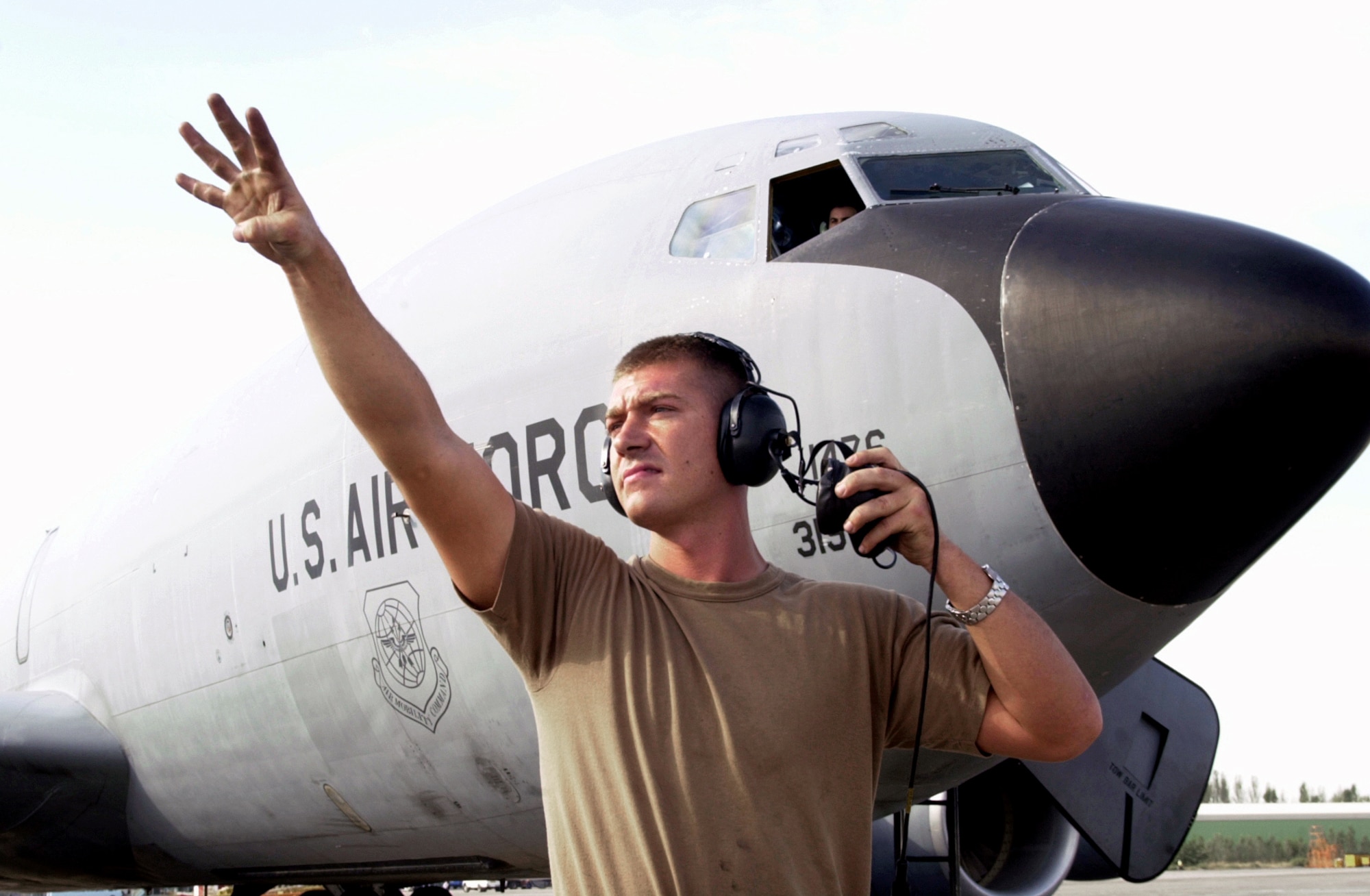 GANCI AIR BASE, Kyrgyzstan -- Airman 1st Class Ryan Van Cleave signals for a communication and navigation specialist during preflight procedures.  Van Cleave and his fellow crew chiefs and maintenance specialists kept the KC-135 Stratotanker fleet here at 100-percent mission capable for 17 consecutive days Aug. 25 through Sept. 10.  (U.S. Air Force photo by Tech. Sgt. James A. Rush)