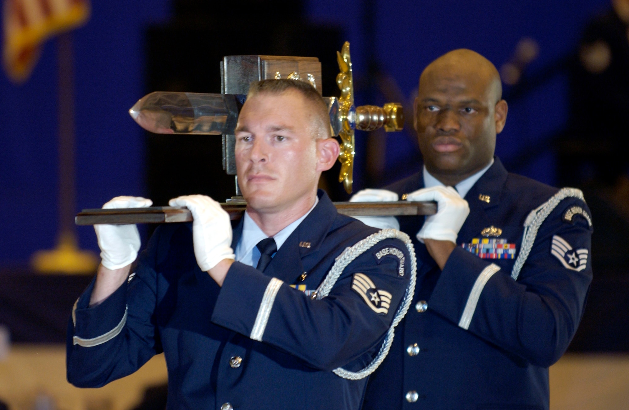 ANDREWS AIR FORCE BASE, Md. -- Staff Sgts. Daniel Perry (front) and Ray Bradshaw bear the Air Force sword for the Order of the Sword ceremony Sept. 13.  Several hundred airmen gathered here to honor and pay tribute to the 20th secretary of the Air Force, Dr. James G. Roche.  The Order of the Sword is the highest honor Air Force noncommissioned officers can give to an individual and is patterned after two orders of chivalry founded during the Middle Ages in Europe.  Perry is assigned to Wright-Patterson Air Force Base, Ohio, and Bradshaw is assigned to Kadena Air Base, Japan.  (U.S. Air Force photo by Master Sgt. Jim Varhegyi)
