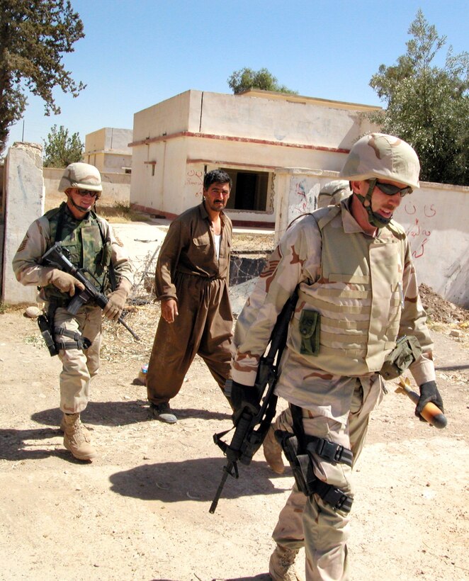 KIRKUK, Iraq -- Master Sgts. Dale Griffin (right) and Jerry Dunn remove an Iraqi training mortar from a neighborhood near a former Republican Guard facility here.  Griffin and Dunn are explosive ordnance technicians deployed to nearby Kirkuk Air Base. (U.S. Air Force photo by Maj. Robert Couse-Baker)