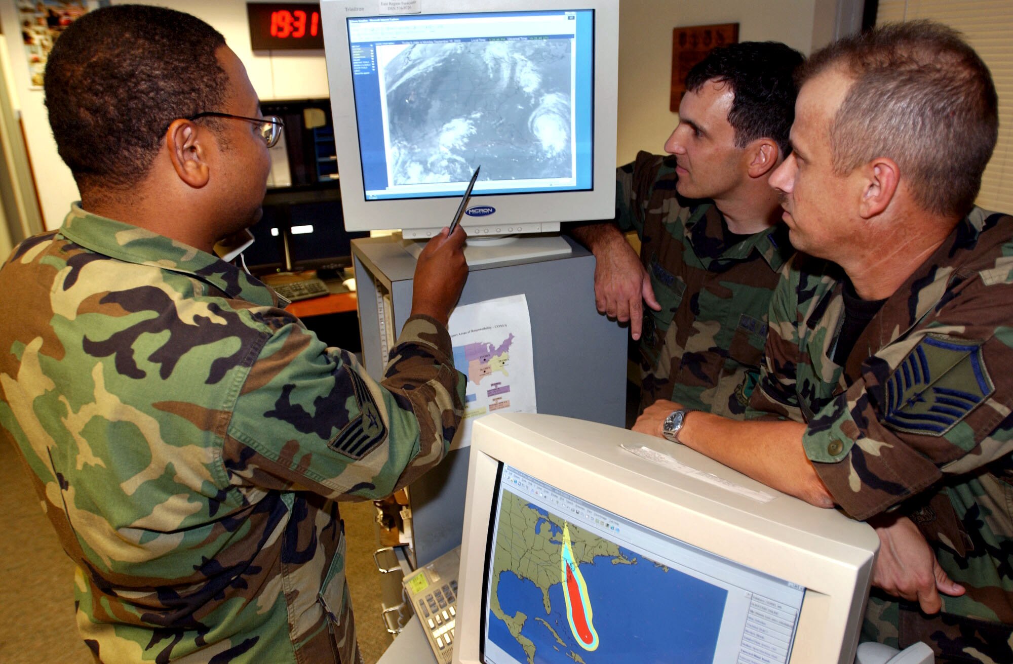 DOVER AIR FORCE BASE, Del. -- Staff Sgt. Jason Bowry points out the projected pathway of Hurricane Isabel to Capt. Paul Gifford and Master Sgt. Arlen Lewis.  All three work in the 436th Operations Support Squadron's weather flight here.  (U.S. Air Force photo by Kristin Royalty)