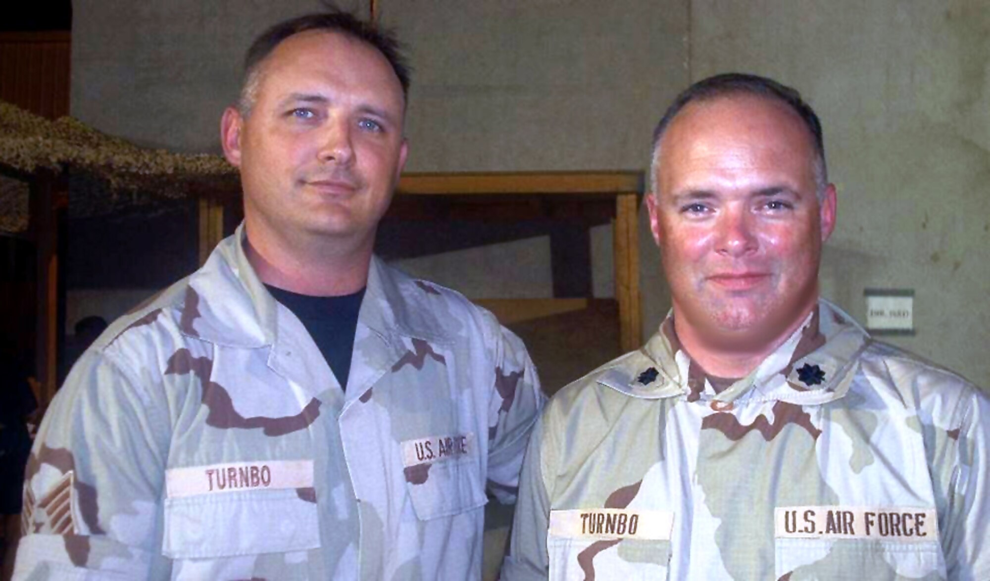 AL UDEID AIR BASE, Qatar -- Tech. Sgt. Robert Turnbo stands with his cousin, Lt. Col. Kevin Turnbo, after the two met while deployed here.  The two realized they were relatives after the sergeant received family history documents from his wife in the United States.  Both airmen are assigned to the U.S. Central Air Forces Combined Air Operations Center here.  (Courtesy photo)