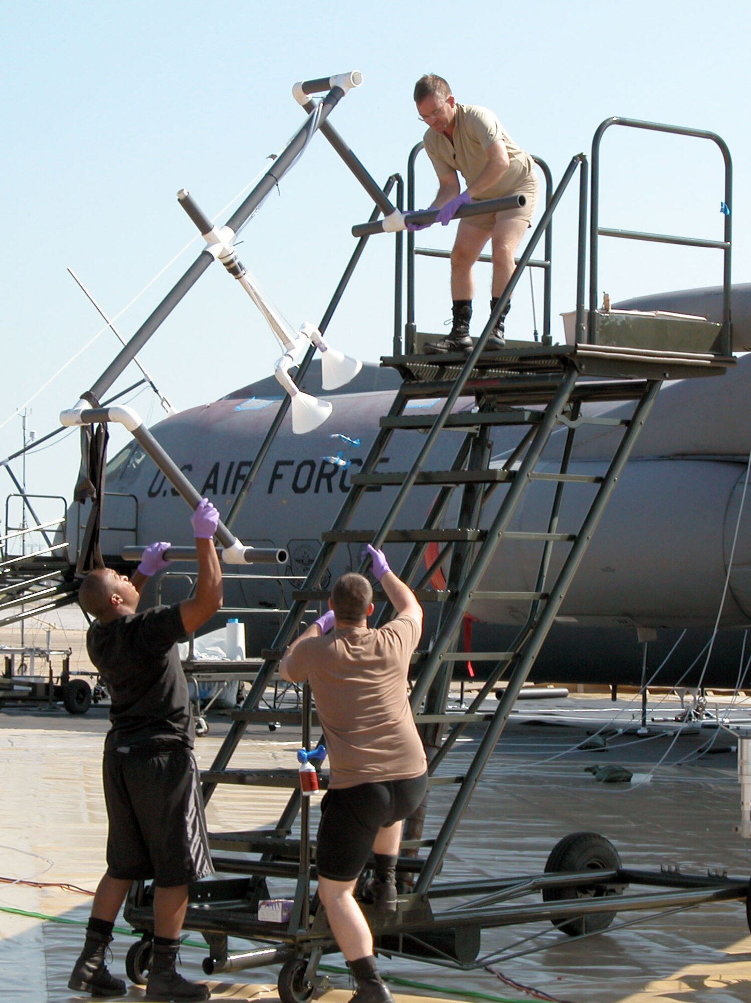 EGLIN AIR FORCE BASE, Fla. -- Members of the Large Airframe Decontamination Demonstration remove vapor-collection units from the wing of a C-141 Starlifter here.  The units use suction to determine the level of contamination of the aircraft after a simulated chemical attack using a non-toxic "stimulant."  (U.S. Air Force photo by Tara Cheek)
