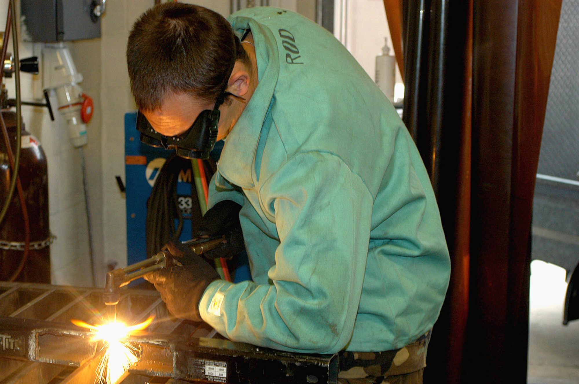 ROYAL AIR FORCE LAKENHEATH, England (AFPN) -- Airman 1st Class Carlos Rodriguez cuts a piece of metal in the metals technology shop here.  He is an aircraft metal technology apprentice assigned to the base's 48th Equipment Maintenance Squadron.  (U.S. Air Force photo by 1st Lt. Ed Ekpoudom)