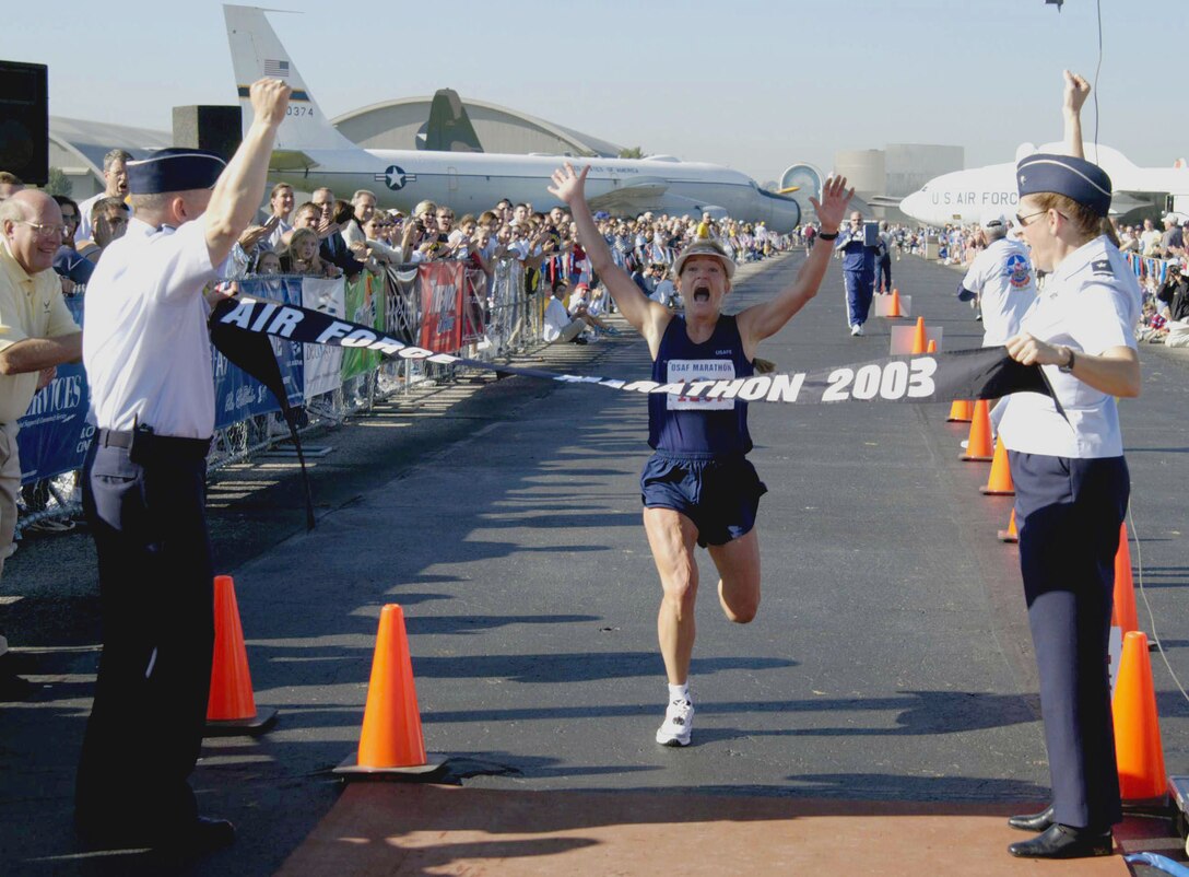 WRIGHT-PATTERSON AIR FORCE BASE, Ohio (AFPN) -- Lt. Gen. Dick Reynolds, Aeronautical Systems Center commander, and Brig. Gen. Ro Bailey, ASC Aeronautical Enterprise Program director, cheer Jill Metzger as she finishes the 26.2-mile Air Force Marathon.  Metzger was the overall top women's finalist at 3 hours, 5 minutes and 35 seconds. (Air Force photo by 2nd Lt. David Cromwell)