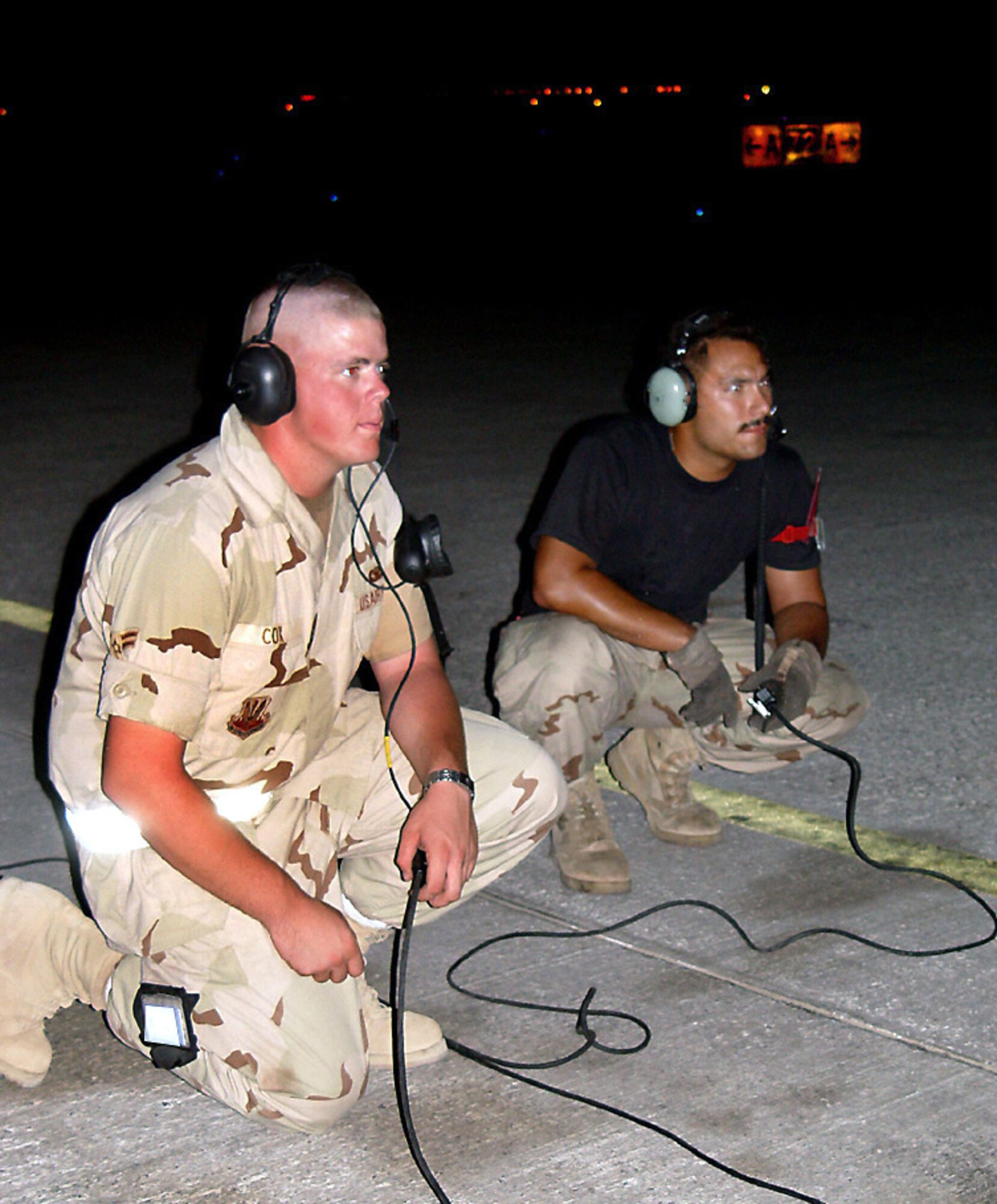 OPERATION ENDURING FREEDOM -- Airmen 1st Class Andrew Cox (left) and Joshua Massey prepare to launch a KC-135 Stratotanker on a night mission supporting Operation Enduring Freedom.  Cox is assigned to the 380th Expeditionary Security Forces Squadron, and was given the opportunity to be a crew chief for a day.  Massey is a KC-135 crew chief from the 380th Expeditionary Aircraft Maintenance Squadron.  (U.S. Air Force photo by Senior Airman Rachel Bush)