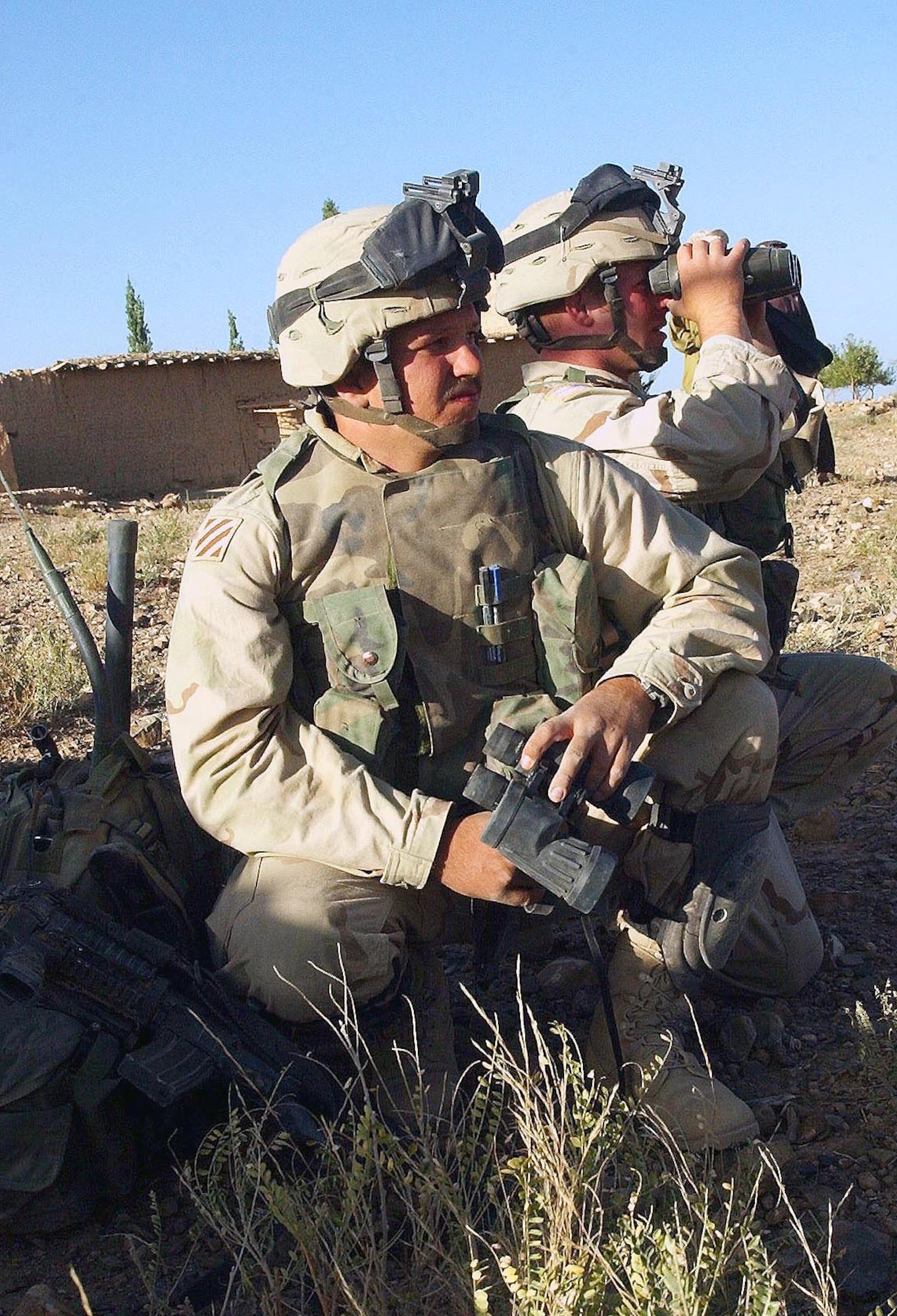 SHKIN FIRE BASE, Afghanistan -- Staff Sgt. Travis Stricker (left) and Airman 1st Class Justin Pilant look into Pakistan from an area near here, in search of al-Qaida terrorists who launched a rocket attack on their base.  If the airmen make contact with the enemy, they will use their radios to direct an air strike on the target.  Both airmen are deployed from the 20th Air Support Operations Squadron at Fort Drum, N.Y.  (U.S. Air Force photo by Staff Sgt. Russell Wicke)