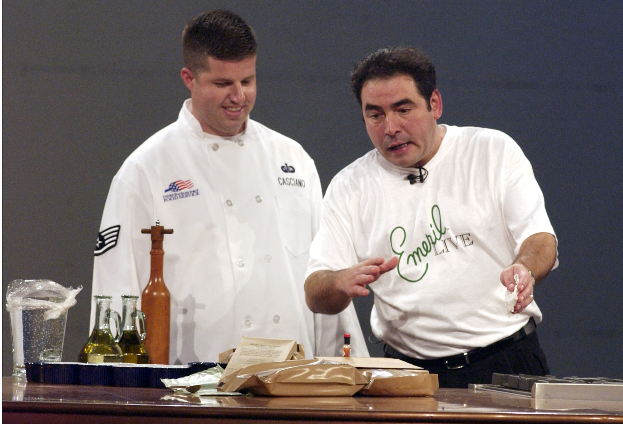 MCGUIRE AIR FORCE BASE, N.J. -- Staff Sgt. Kevin Casciano, a chef with the 305th Services Squadron, and Emeril Lagasse discuss meals ready to eat during the Sept. 25 taping of the celebrity chef's Thanksgiving special here.  The show is scheduled to air Nov. 16.  Check local listings for times.  (U.S. Air Force photo by Denise Gould)