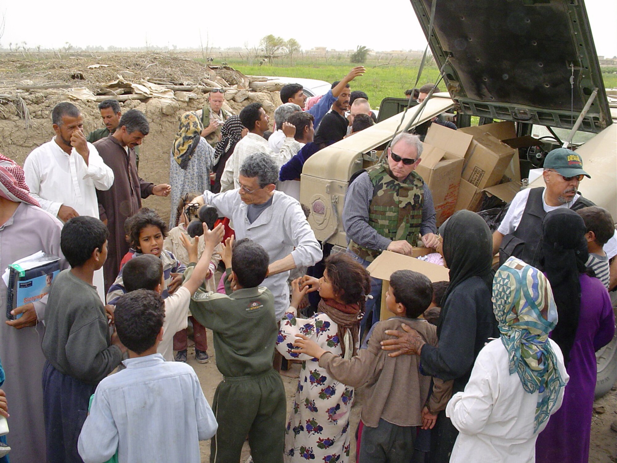 VEDGHA, Iraq - Chaplain (Lt. Col.) Rich Hall (wearing the flack vest) hands out clothing, shoes, food and toys during a humanitarian relief mission here recently.  Members of the 447th Air Expeditionary Group's chaplaincy, Air Force Office of Special Investigations, medical and security forces squadron's assisted with the mission.  (U.S. Air Force photo by Master Sgt. Sean E. Cobb)