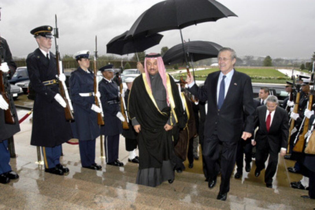 Secretary of Defense Donald H. Rumsfeld (right) uses an umbrella to shield his guest Kuwaiti Minister of Defense Sheikh Jaber Al Mubarek Al-Hamad Al-Sabah from the rain as he arrives at the Pentagon on April 1, 2004. Rumsfeld and Deputy Secretary of State Richard L. Armitage delivered remarks at a ceremony honoring Kuwait as a Major Non-NATO Ally of the United States. 