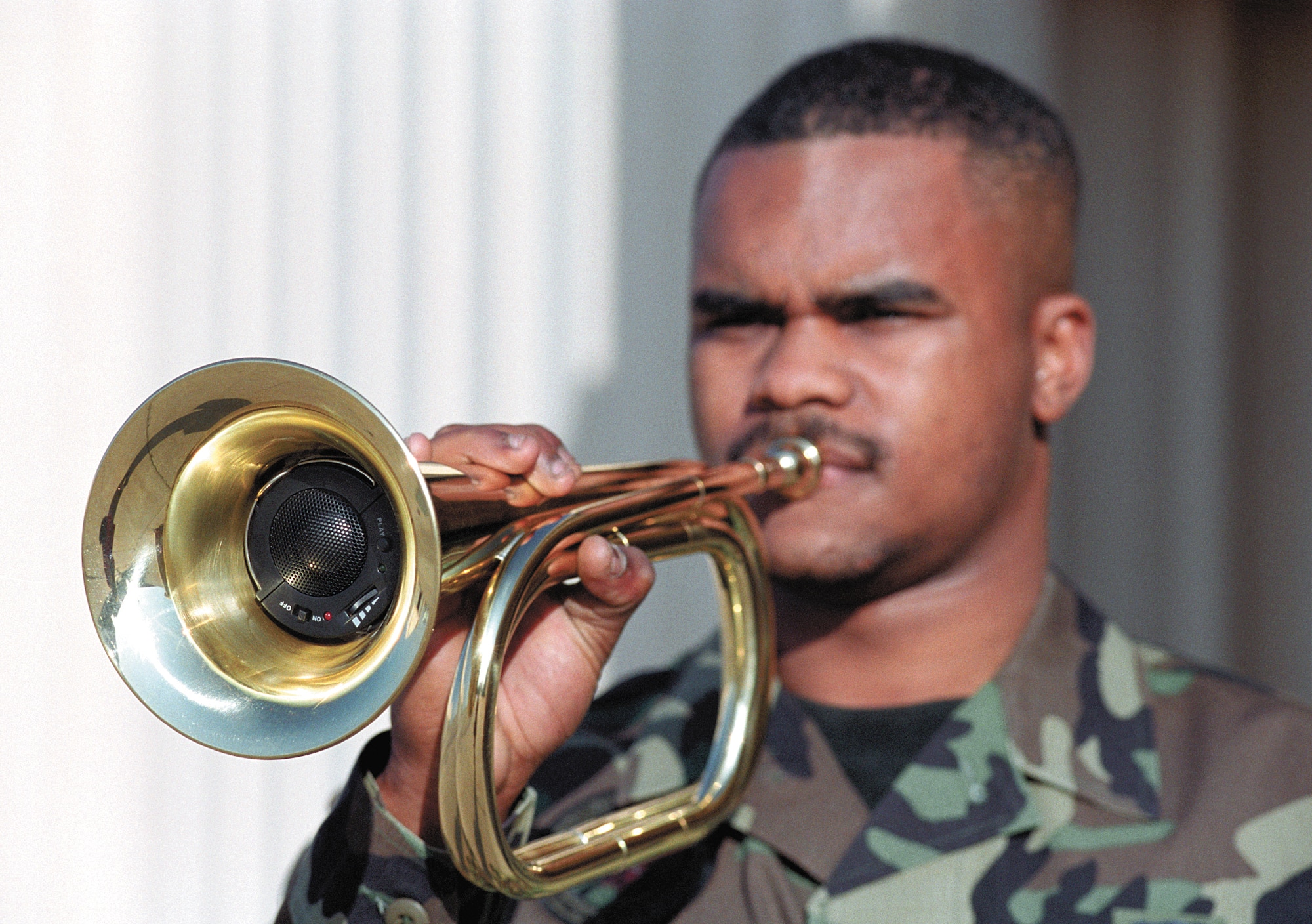 TINKER AIR FORCE BASE, Okla. -- A recorder that plays "Taps" tucks inside a special bugle held by Senior Airman Eric Young.  Tinker Air Force Base Honor Guard members said they welcome the bugles over the stereos they had to use in the past.  Airman Young is an honor guard supply technician and bugler.  (U.S. Air Force photo by Margo Wright)