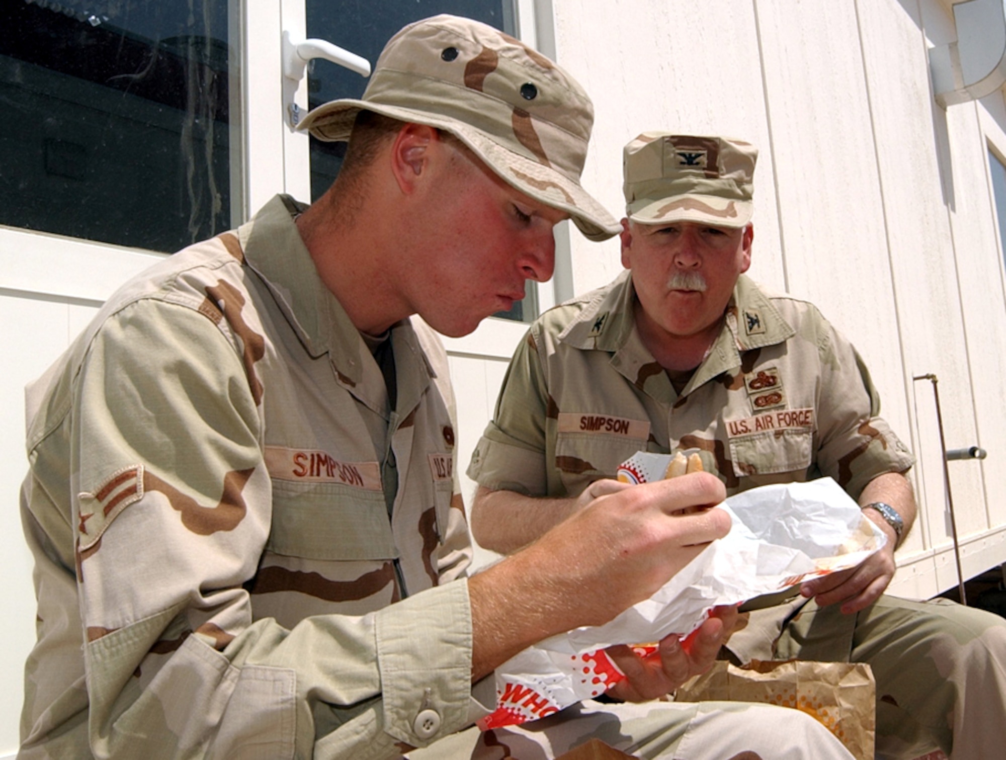 SOUTHWEST ASIA -- Col. Bill Simpson shares lunch with his son, Airman 1st Class Doug Simpson.  Colonel Simpson is from Tinker Air Force Base, Okla., and Airman Simpson is from Pope AFB, N.C.  They are at the same forward-deployed location here.  (U.S. Air Force photo by Airman 1st Class J.G. Buzanowski)