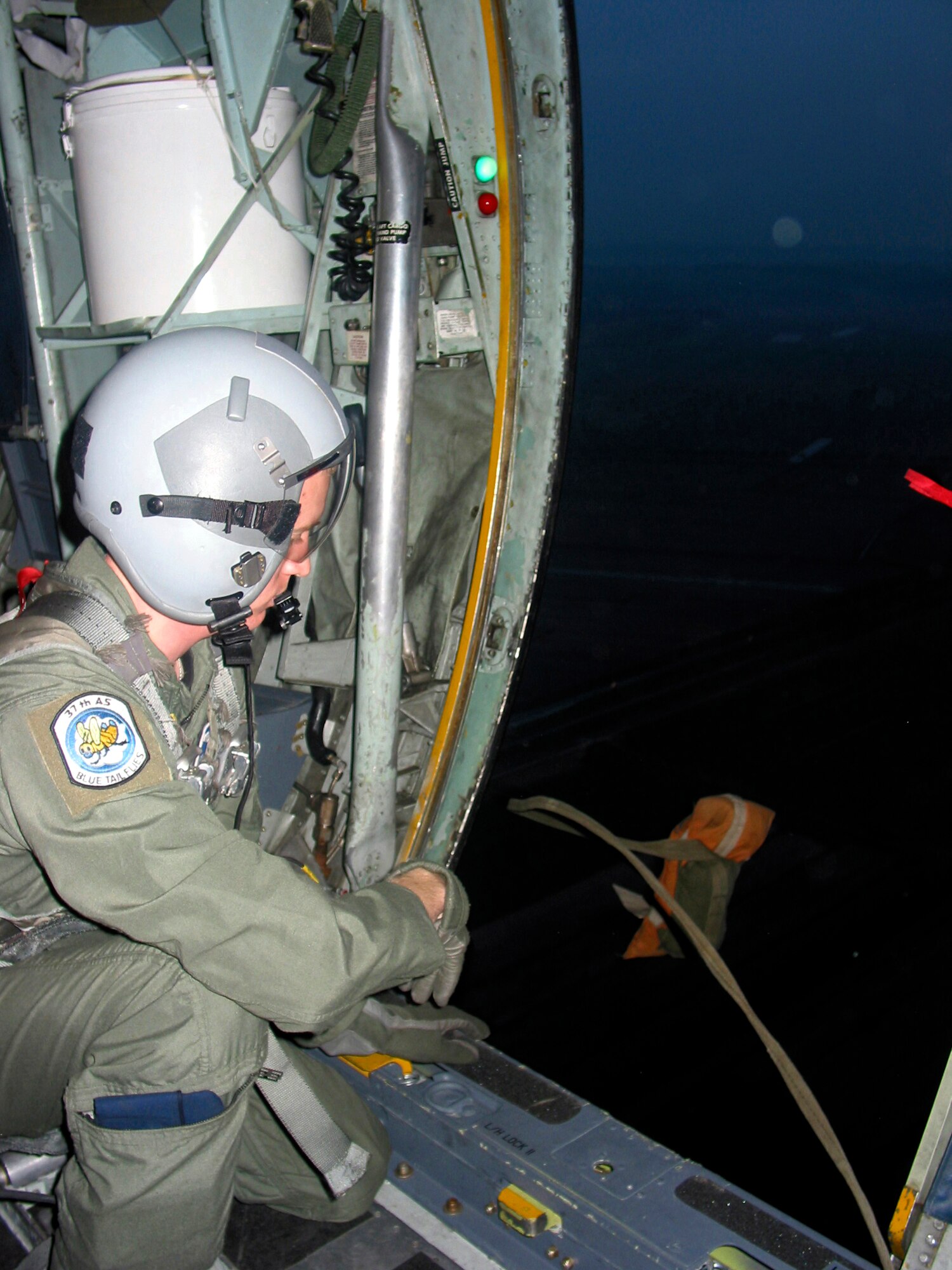 PISA, Italy -- Airman 1st Class John Columbia throws a 15-pound sandbag out the rear side door of a C-130 Hercules to test drop-zone accuracy during Exercise Leaning Tower here April 2. The weeklong training mission also included low-level flights and night-vision goggle training.  Airman Columbia is a loadmaster with the 37th Airlift Squadron at Ramstein Air Base, Germany.  (U.S. Air Force photo by 1st Lt. Tracy Giles)