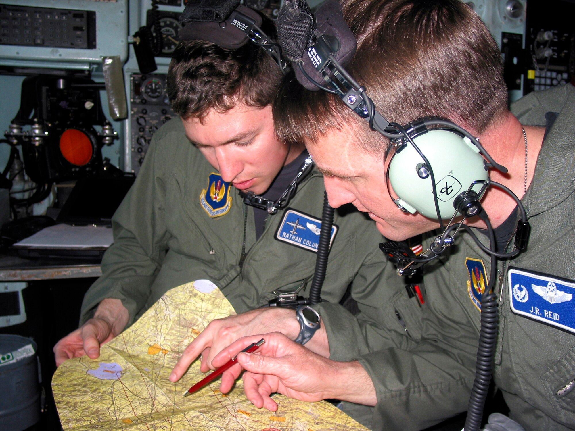 PISA, Italy -- First Lt. Nathan Colunga (left) reviews a map showing a planned flight route with Lt. Col. John Reid in the cockpit of a C-130 Hercules during Exercise Leaning Tower here April 2.  The weeklong training mission included low-level flights and air drops using night-vision goggles.  Liutenant Colunga is assigned to the 37th Airlift Squadron and Colonel Reid is the 37th AS commander from Ramstein Air Base, Germany.  (U.S. Air Force photo by 1st Lt. Tracy Giles)