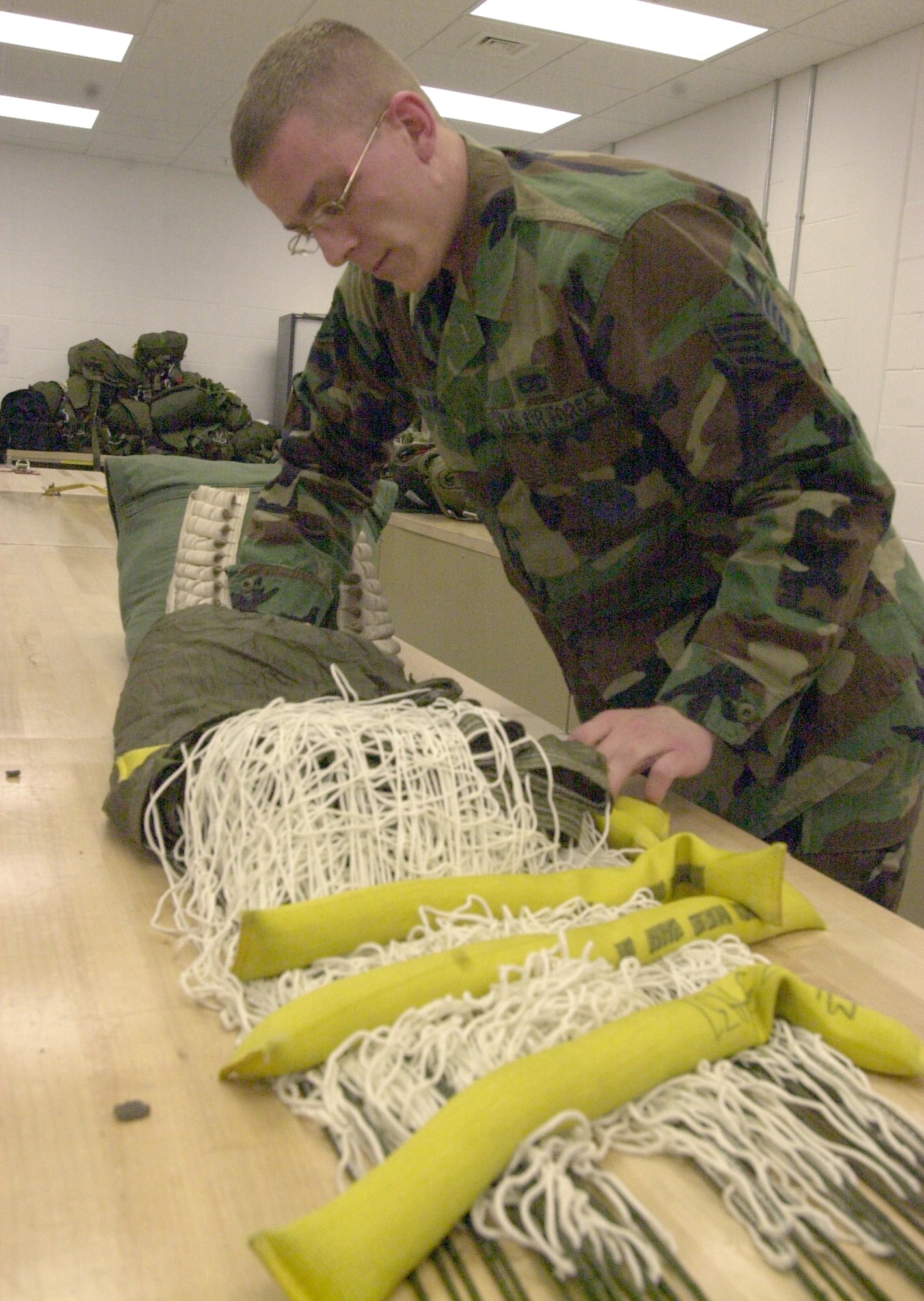 ROYAL AIR FORCE MILDENHALL, England -- Staff Sgt. Paul McArdle repacks a parachute after inspecting it to ensure its safety.  He is the fabrication section chief for the100th Maintenance Squadron's survival equipment flight here.  (U.S. Air Force photo by Karen Abeyasekere)