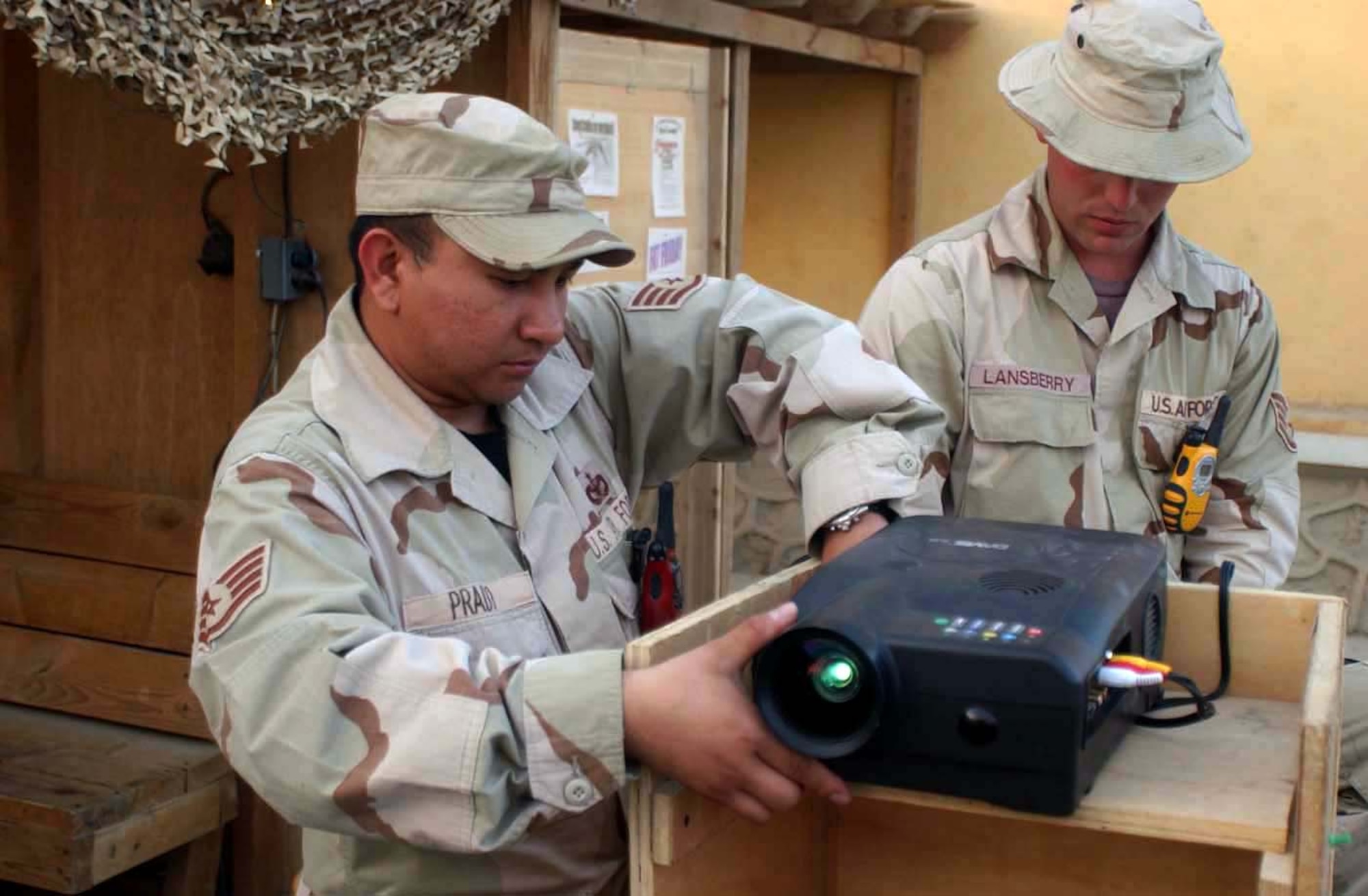 BAGRAM AIR BASE, Afghanistan -- Staff Sgt. Eugene Prado (left) sets up equipment for movie night here with assistance from Staff Sgt Joshua Lansberry.  Both sergeants are assigned to the 455th Expeditionary Security Forces Squadron.  (U.S. Air Force photo by Master Sgt. Jeff Szczechowski)