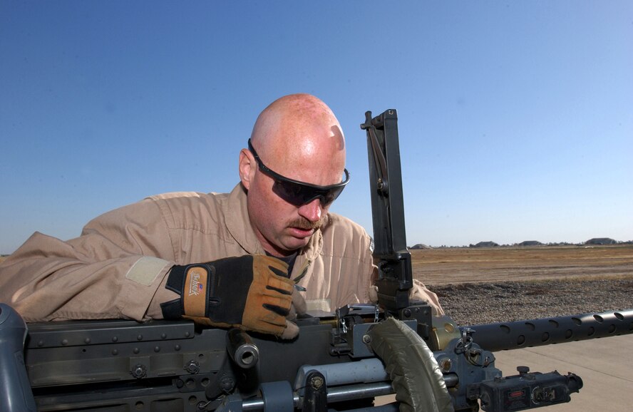 BALAD AIR BASE, Iraq -- Tech. Sgt. John Buckler inspects one of two .50-caliber machine guns aboard an HH-60 Pave Hawk helicopter.  Sergeant Buckler is a flight engineer with 64th Expeditionary Rescue Squadron here, and he is deployed from the 41st Rescue Squadron at Moody Air Force Base, Ga.  (U.S. Air Force photo by Staff Sgt. Prentice Colter)        