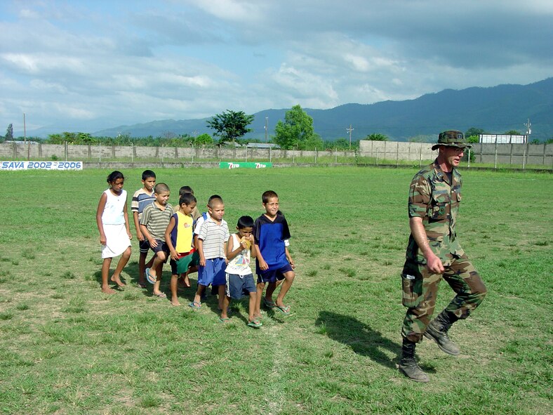 SABA, Honduras -- Capt. Steve Christoff leads a group of Honduran children in a march at a soccer field.  Airmen from the 934th Civil Engineer Squadron were here participating in an exercise where they made improvements to the base camp and helped with projects being done in local villages.  (U.S. Air Force photo by Master Sgt. Mike McGuire)