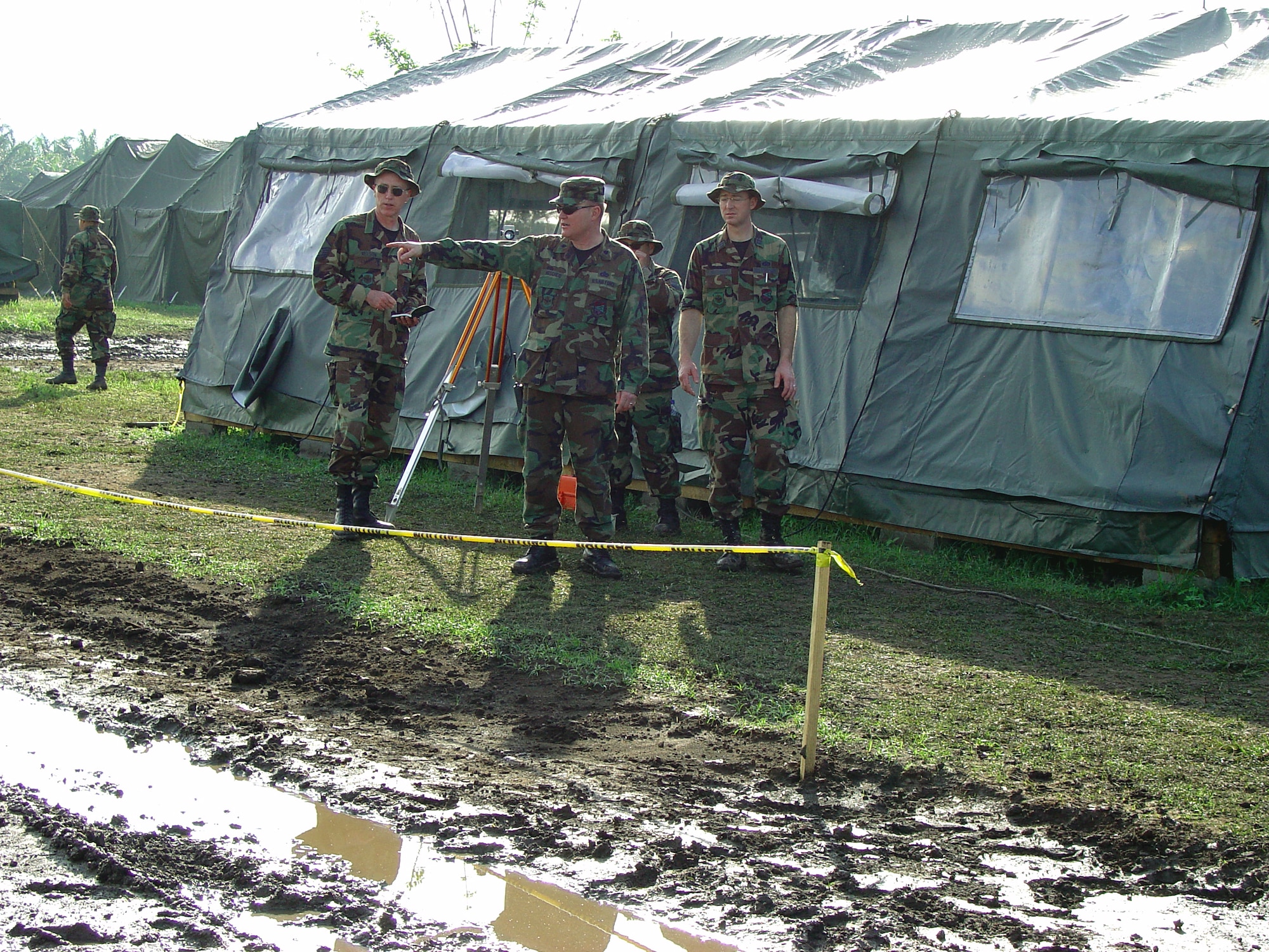 SABA, Honduras -- Amdist the mud, Lt. Col. Randy Hoscheid shows (from left) Master Sgts. David Nelson and Jose Gonzalez-Rocha, and Capt. Steve Christoff where the shower and latrine trailers are to be set.  The Airmen from the 934th Civil Engineer Squadron were here to participate in an exercise where they made improvements to the base camp and helped with projects in local villages.  Colonel Hoscheid is the 934th CES commander.  (U.S. Air Force photo by Tech. Sgt. Robert Walz)