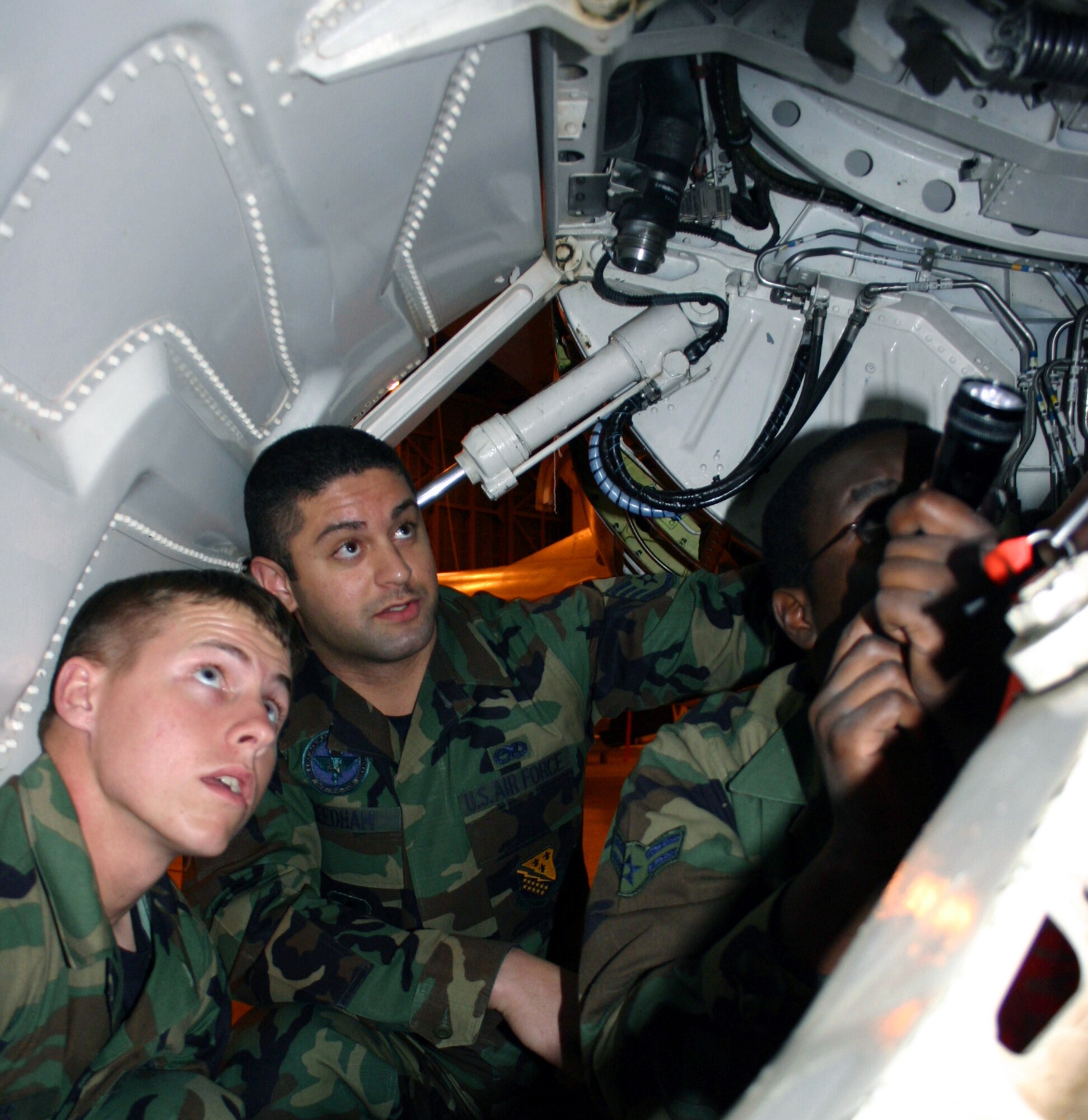 SHEPPARD AIR FORCE BASE, Texas -- Staff Sgt. Kalaeone Needham (center) has students Airman Ryan Ross (left) and Airman 1st Class Sakawa Ogega point out F-16 Fighting Falcon parts during training here.  Sergeant Kalaeone is an instructor in the 362nd Training Squadron and the 250,000th Community College of the Air Force graduate.  (U.S. Air Force photo by Airman 1st Class Jacque Lickteig)