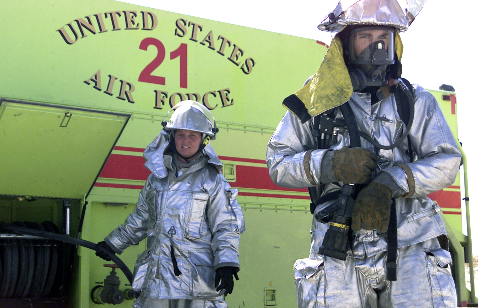 SOUTHWEST ASIA -- Airmen 1st Class Danielle Morris (left) and Paul Dean drag a fire hose from a base firetruck after extinguishing a trailer fire at a forward-deployed location.  Both Airmen are assigned to the 386th Expeditionary Civil Engineer Squadron's fire department.  Airman Morris is deployed from the 28th Civil Engineer Squadron at Ellsworth Air Force Base, S.D., and Airman Dean is deployed from the 16th CES at Hurlburt Field, Fla.  (U.S. Air Force photo by Capt. Tom Knowles)
