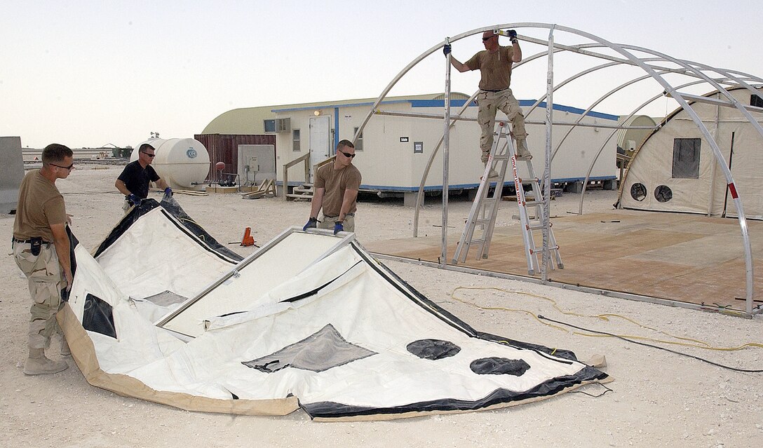 SOUTHWEST ASIA -- (Left to right) Airman 1st Class Brandon Brayley, Tech. Sgt. Tom Stevens and Staff Sgts. Gary Garhammer and George Barnes erect a shelter at a forward-deployed location.  The Airmen are assigned to the 379th Expeditionary Civil Engineer Squadron.  (U.S. Air Force photo by Senior Airman Wes Auldridge)