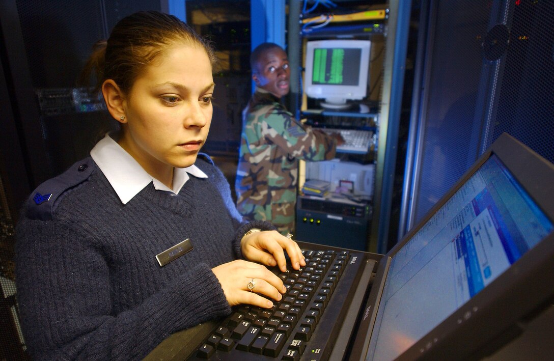 ROYAL AIR FORCE MILDENHALL, England -- Senior Airman Barbara Garcia (front) creates a user account while Staff Sgt. Adrian Langford uses a combat information transport system to monitor the network here April 19. Airman Garcia and Sergeant Langford are network control center technicians with the 424th Communications Squadron. (U.S. Air Force photo by Airman 1st Class Franklin J. Perkins)