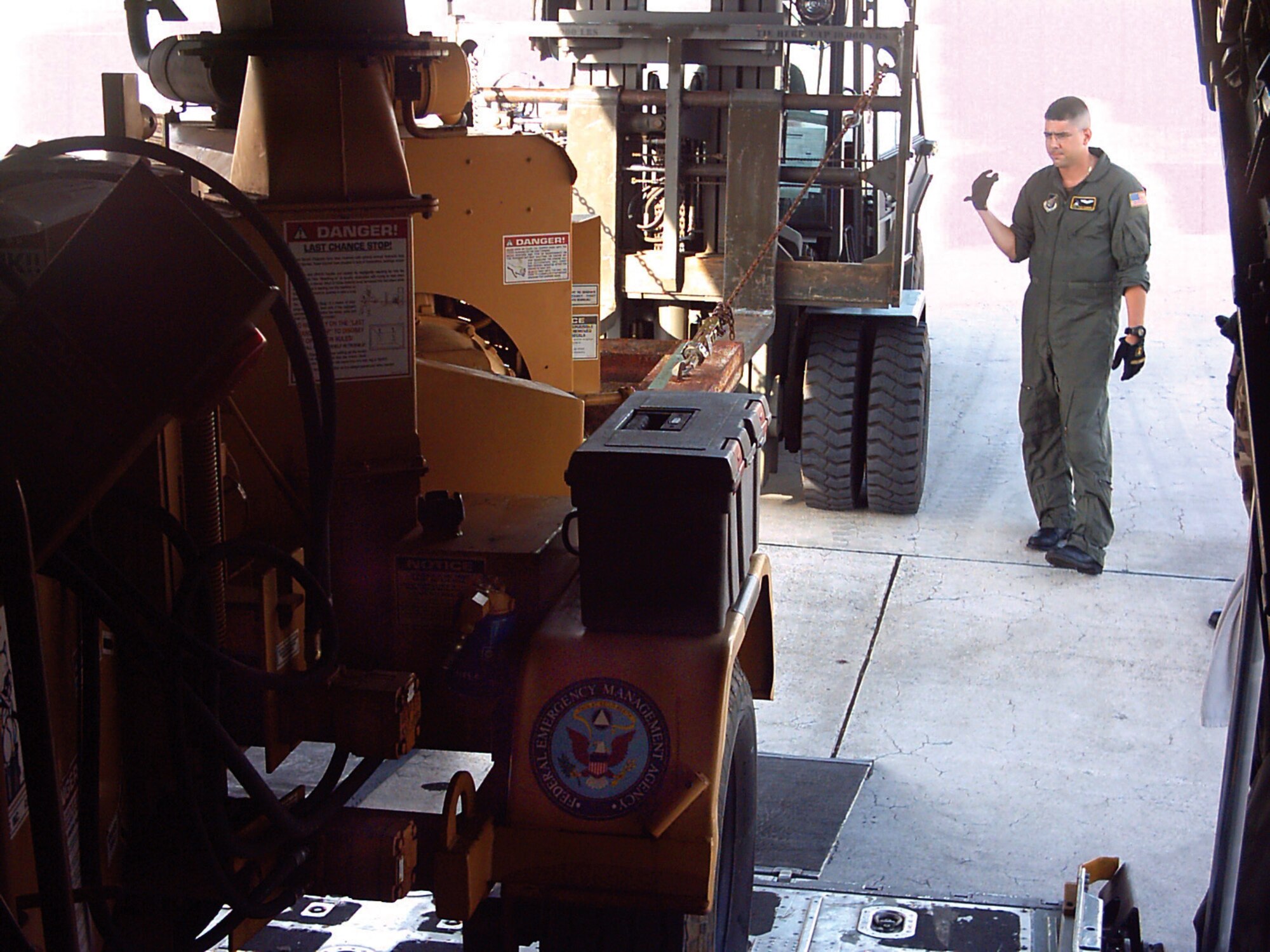 CAROLINE ISLANDS, Micronesia -- Staff Sgt. Ryan Cumrine directs the delivery of a wood chipper for relief aid to the island of Yap.  Typhoon Sudal devastated the island April 10, destroying trees, homes and shutting down the island's infrastructure.  Crews from Yokota Air Base, Japan, supported relief efforts to the island by delivering 31 passengers and 102.4 short tons of cargo out of Andersen AB, Guam.  (U.S. Air Force photo by Capt. Jason Fodor)