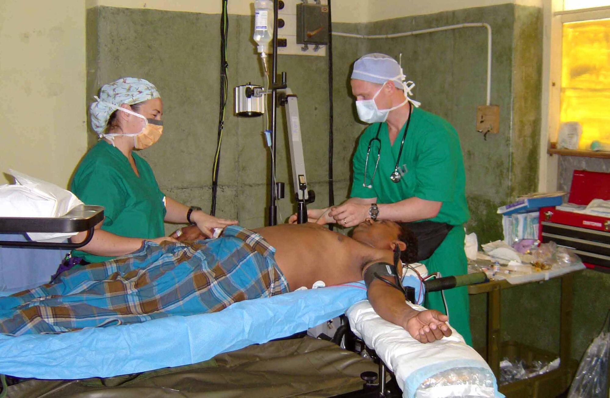 JAFFNA, Sri Lanka -- Army Capt. Kate Harrison (left) and Maj. Troy Osborn prepare a 41-year-old Sri Lankan man for surgery to remove of keloid scars on his chest.  Captain Harrison is an operating room nurse with the 135th Field Surgical Team in Yongsan Army Garrison, South Korea.  Major Osborn is the 374th medical group anesthesia department medical director at Yokota Air Base, Japan.  The medical specialists are here as part of a humanitarian surgical training mission, which continues through May 2.  (U.S. Air Force photo by Maj. Kris Meyle)