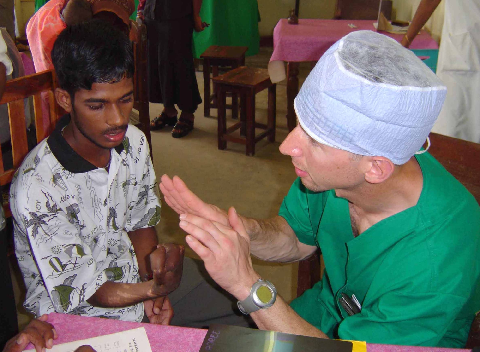 JAFFNA, Sri Lanka -- Army Maj. (Dr.) John Tis explains to a young Sri Lankan man the potential outcome of an operation to surgically separate his thumb from the rest of his hand.  The scar tissue growth which has fused his fingers together was caused by a land-mine blast near here.  Dr. Tis is a pediatric orthopedic surgeon with the 135th Field Surgical Team in Yongsan Army Garrison, South Korea.  He is here as part of a humanitarian surgical training mission, which continues through May 2.  (U.S. Air Force photo by Maj. Kris Meyle)