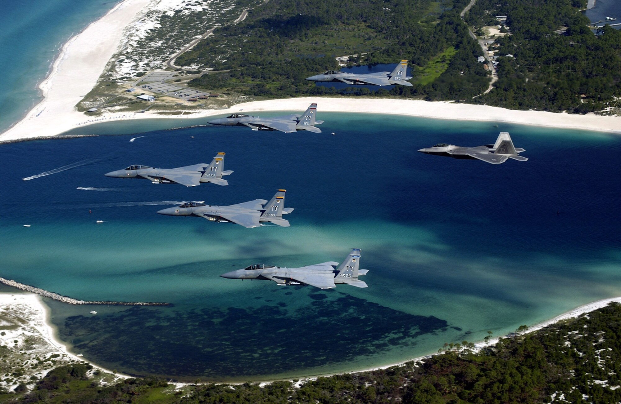 OVER FLORIDA -- A formation of 325th Fighter Wing F-15 Eagles and an F/A-22 Raptor fly above Panama City, Fla.  The Raptor will eventually replace the F-15 Eagle in the Air Force inventory.  (U.S. Air Force photo by Master Sgt. Mike Ammons)