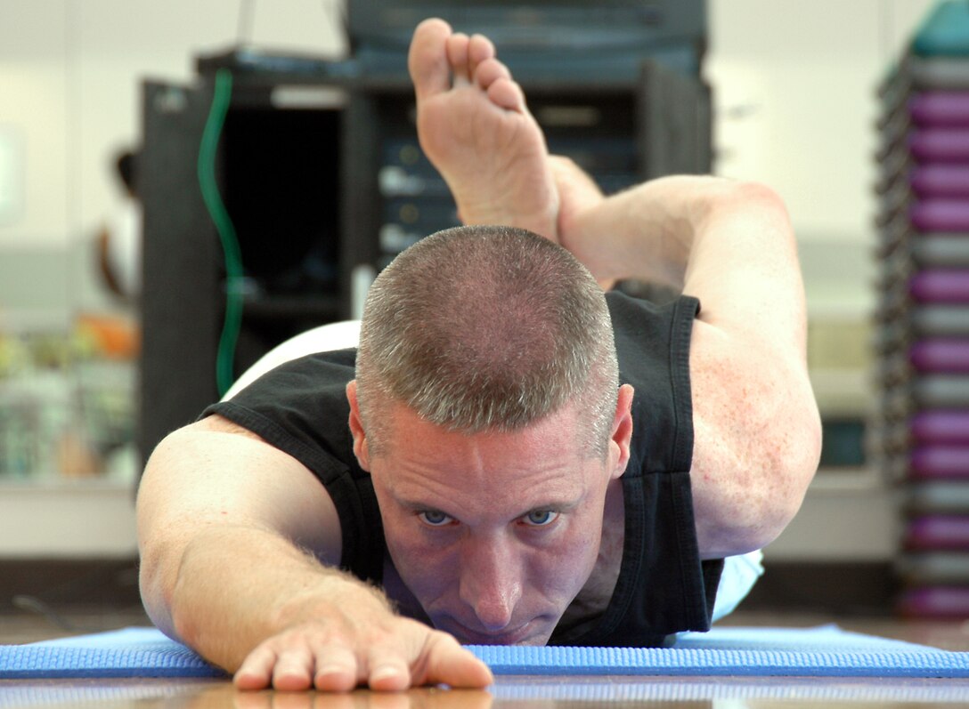 LOS ANGELES AIR FORCE BASE, Calif. -- Capt. William Uhl holds a half-frog asana, or pose, during the cool-down phase of his hour-long yoga class in the fitness center here.  He has been practicing yoga for four years and is certified to teach yoga, Pilates and Power Stretch, which combines yoga and Pilates.  The captain is an analyst for the Space and Missile Systems Center's intelligence directorate. (U.S. Air Force photo by Jason M. Webb)