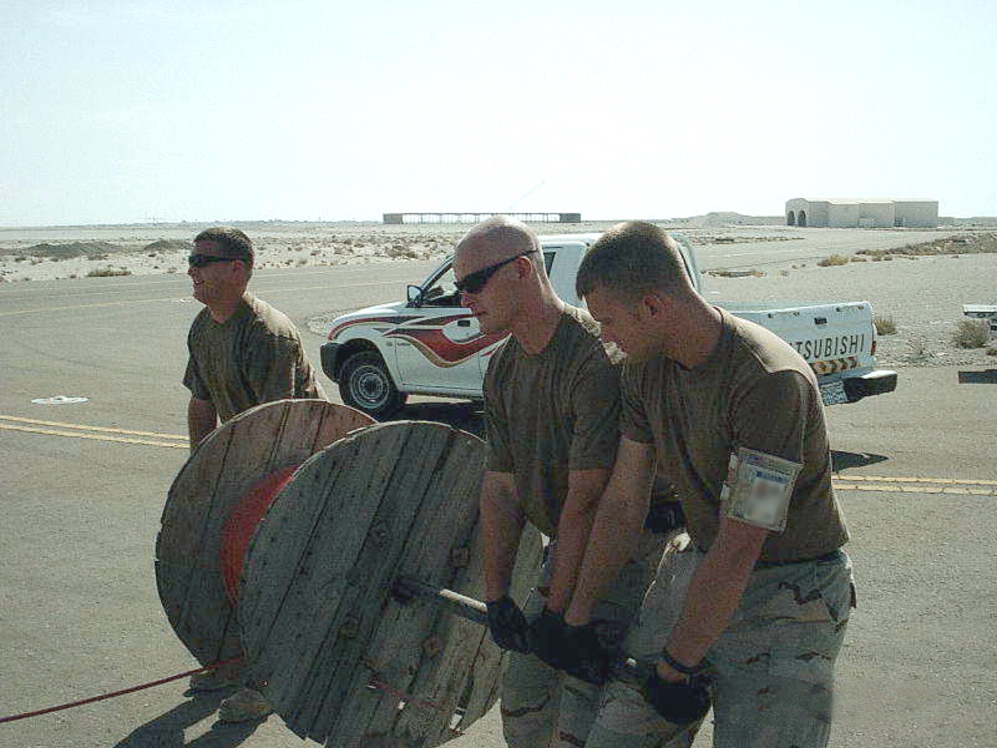 SOUTHWEST ASIA - (from left) Senior Airmen Keith Walters, Tim Ransom and Joseph McFadden played an integral role in getting the airfield lighting back on at a forward-deployed location July 30.  They are assigned to the 380th Expeditionary Civil Engineer Squadron.  (U.S. Air Force digitally altered photo by Tech. Sgt. Melvin Lawrence)